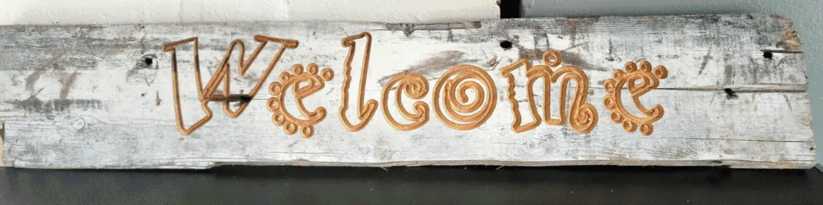 A hand-carved wooden Welcome sign made in the Englewood Works shop