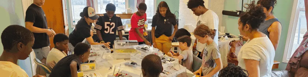 Students building projects at a long worktable