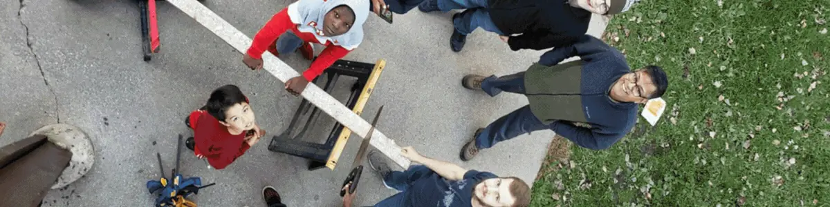 Students carrying lumber in the yard