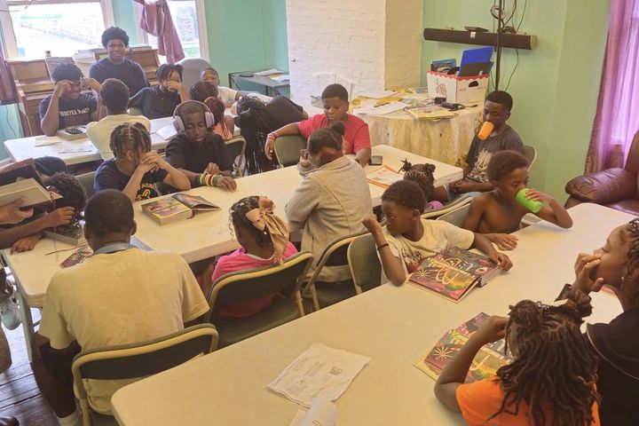 Students working at long tables during the Englewood Works after-school club