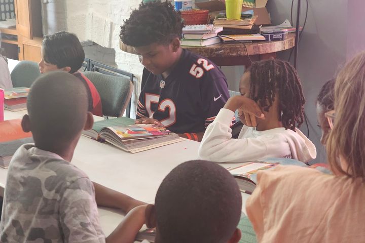 Children reading together at a table
